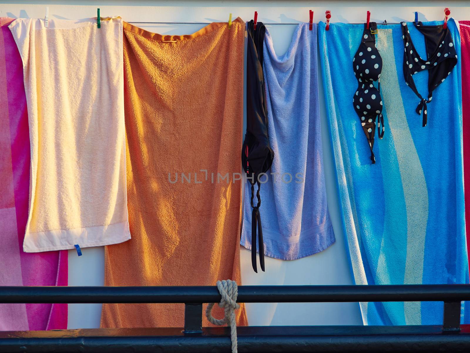 Towels and bathing swim suits drying on the clothesline on a sail boat summer background image