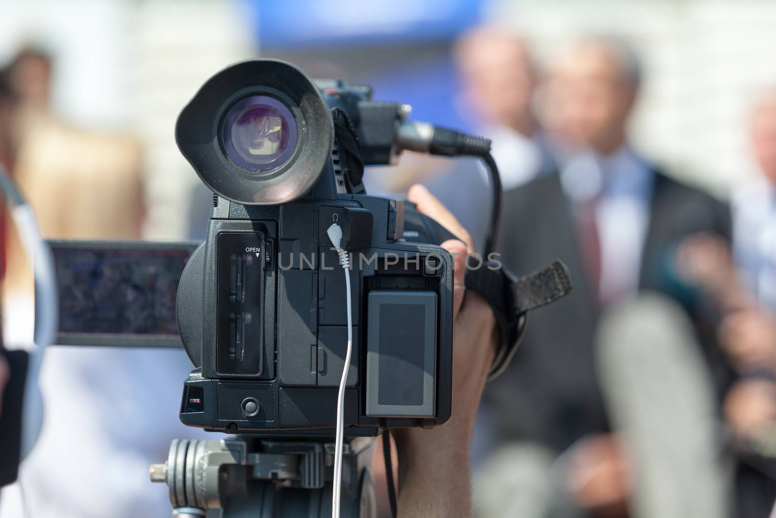 Filming an event with a video camera. Press conference. Spokesperson.