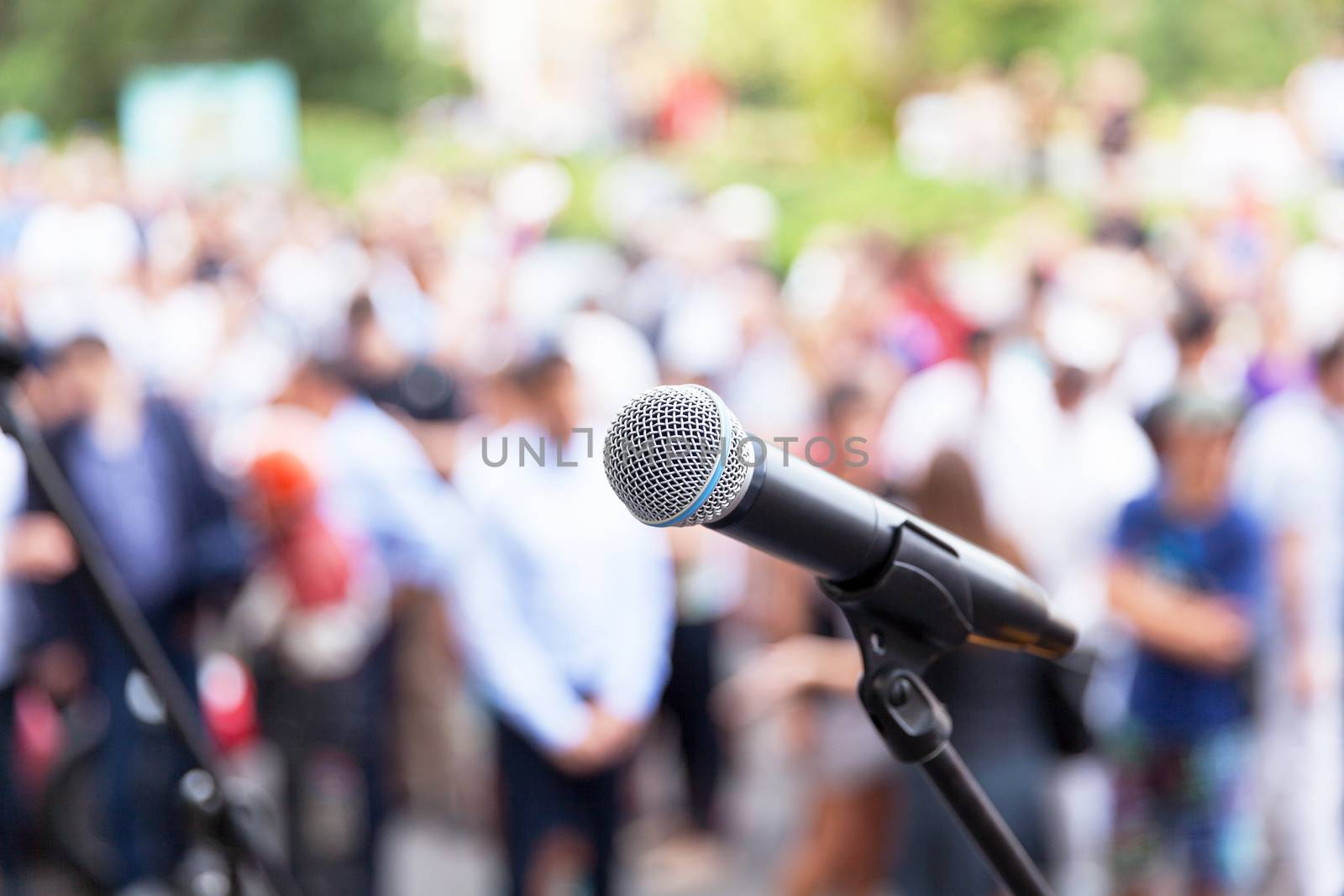 Microphone in focus against blurred audience. Protest. Public demonstration.
