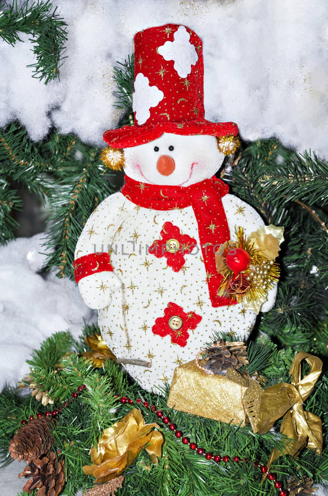 Toy snowman in red cap and scarf on the Christmas tree