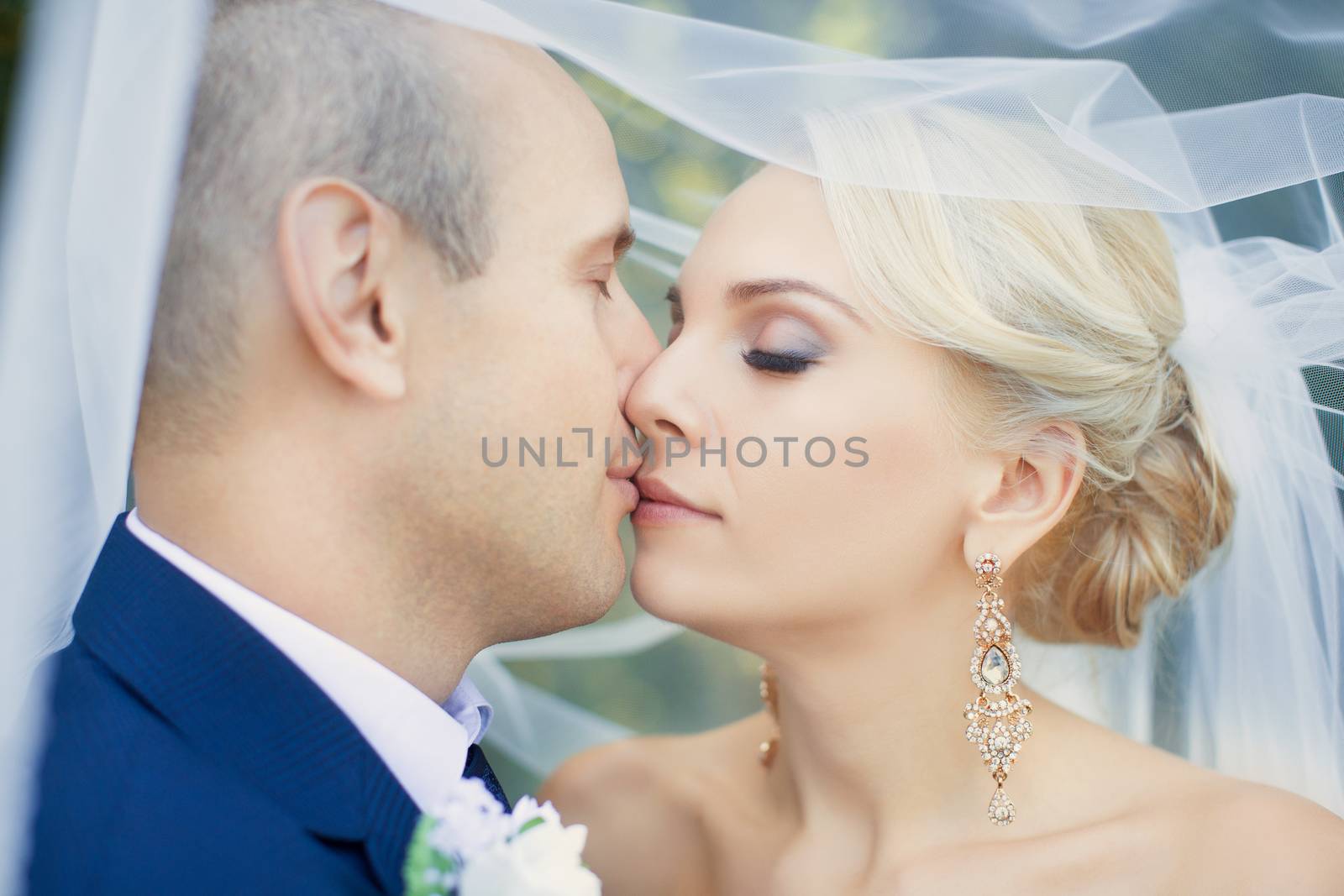 Amazing teen bride gently kisses the groom, close-up