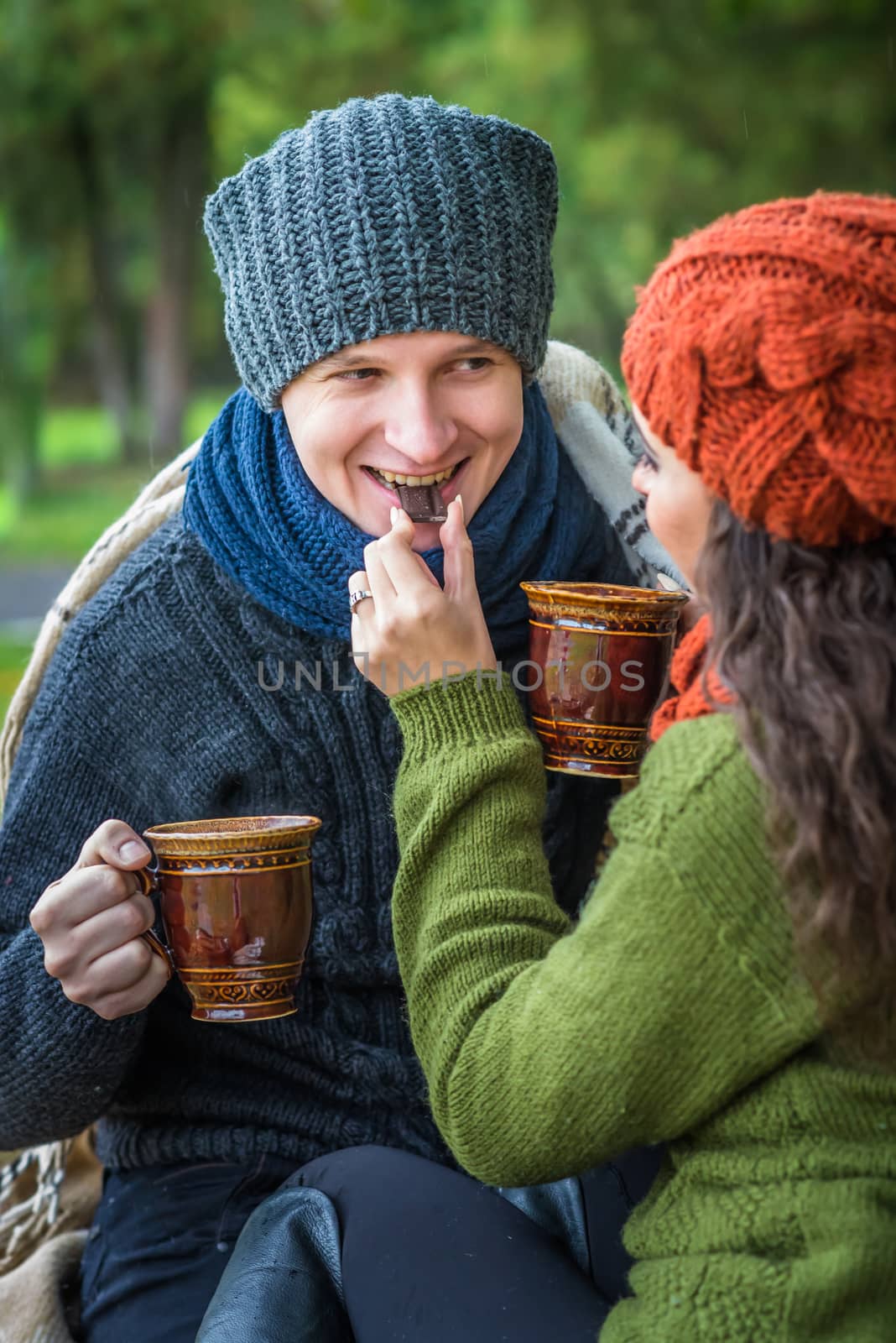 Happy romantic couple at fall drinking coffee in autumn garden