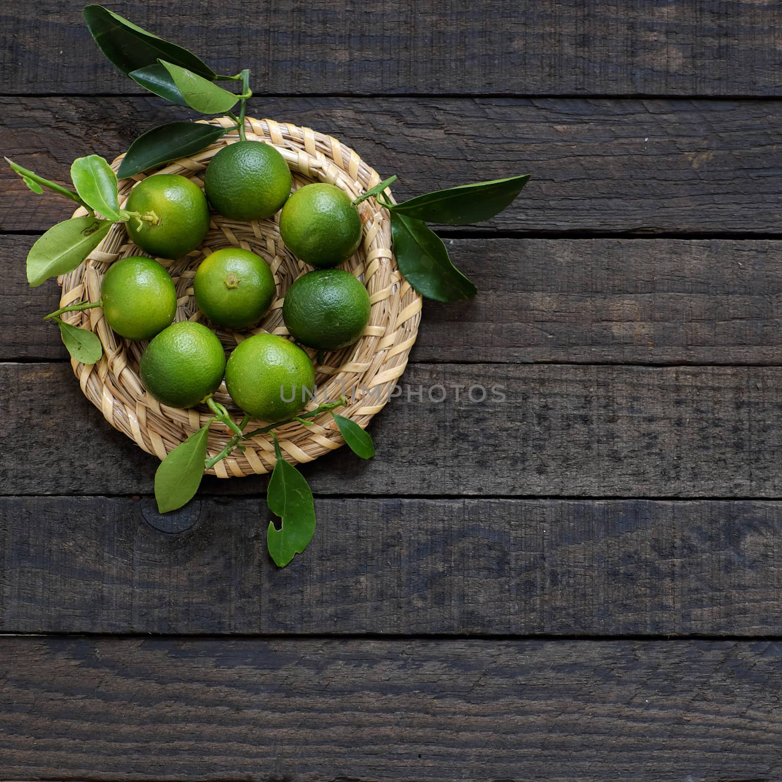 Green Kumquat fruit on wooden background by xuanhuongho