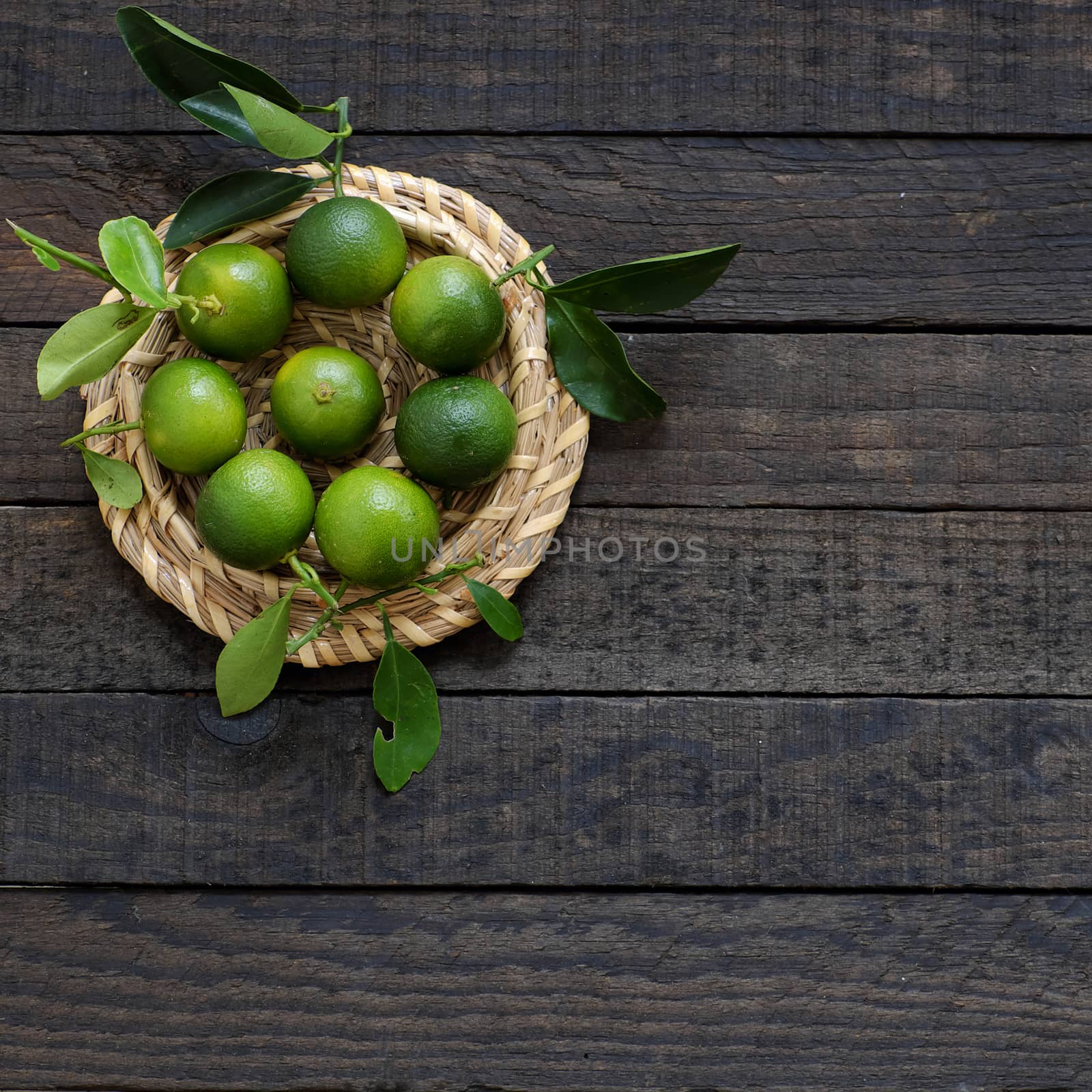 Green Kumquat fruit on wooden background, a popular agriculture product of Vietnam, rich vitamin c, healthy fruit