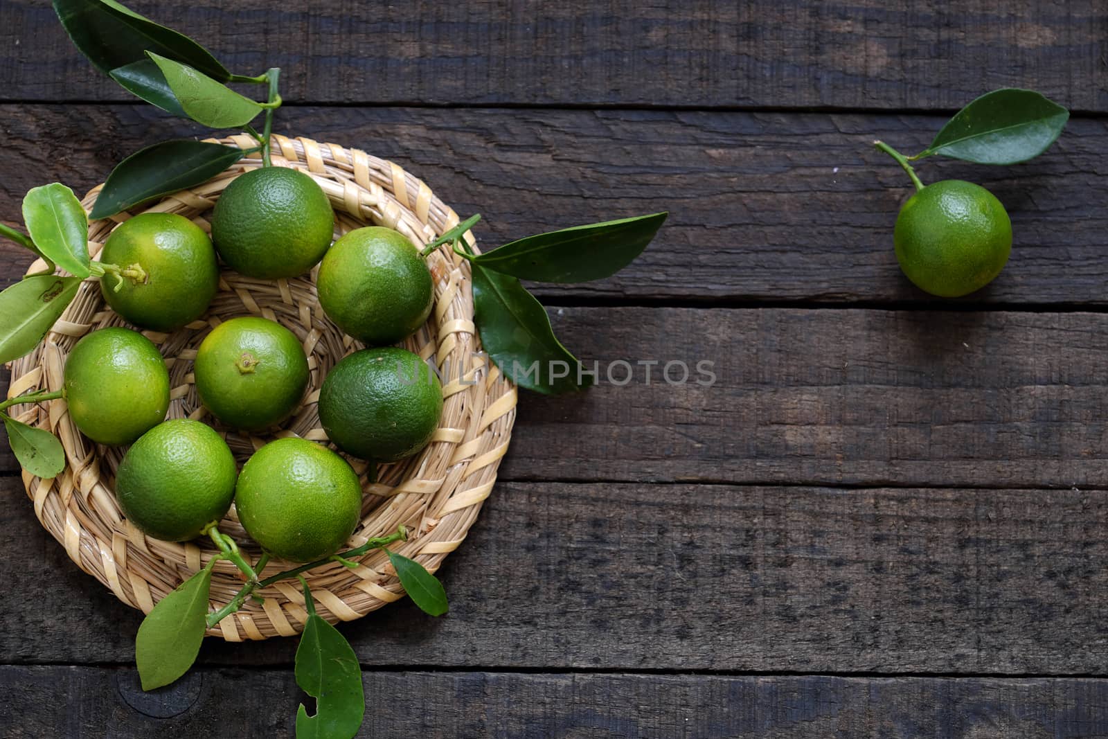 Green Kumquat fruit on wooden background, a popular agriculture product of Vietnam, rich vitamin c, healthy fruit