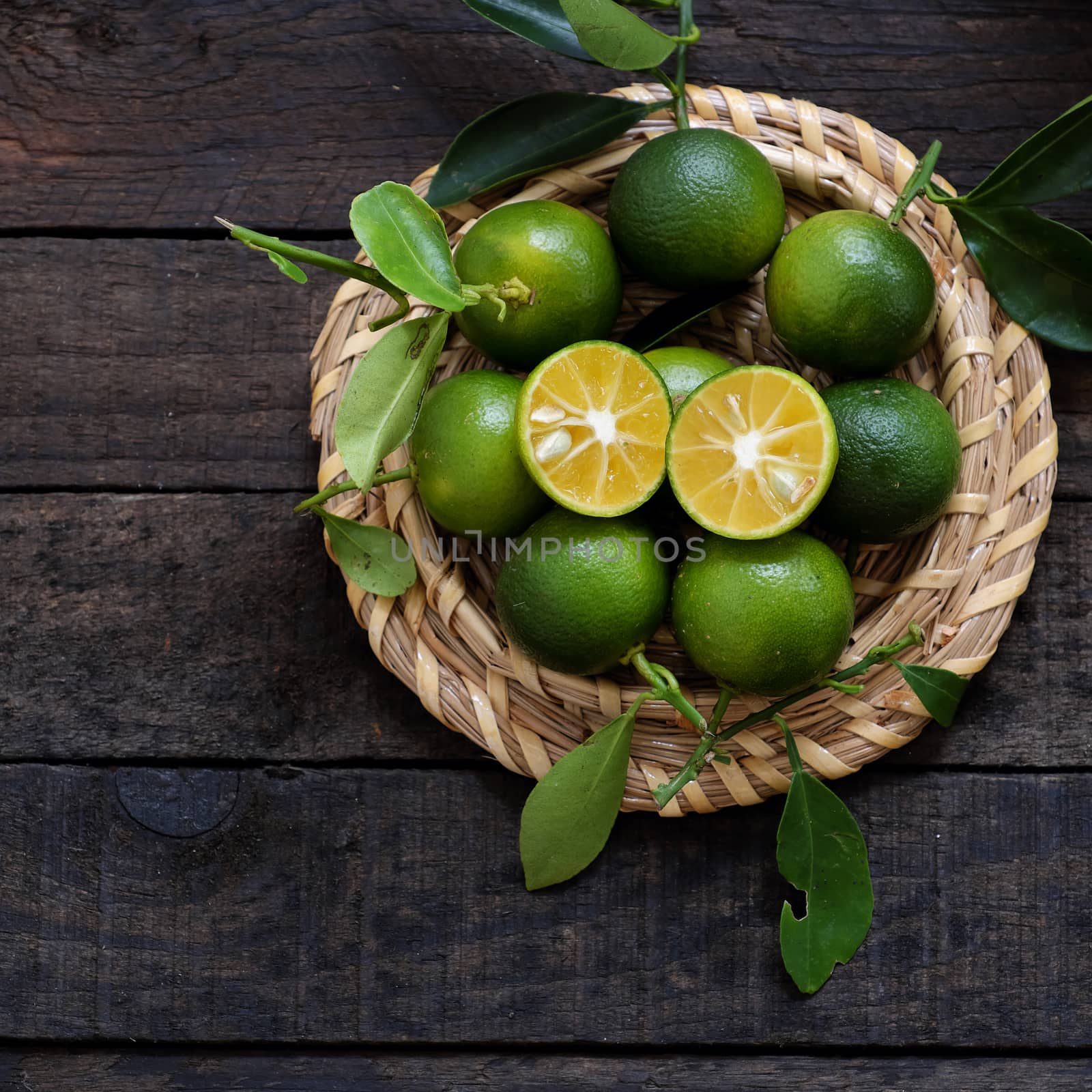 Green Kumquat fruit on wooden background by xuanhuongho