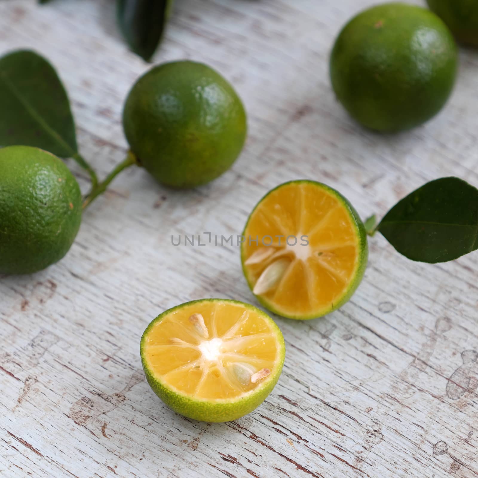 Green Kumquat fruit on wooden background, a popular agriculture product of Vietnam, rich vitamin c, healthy fruit