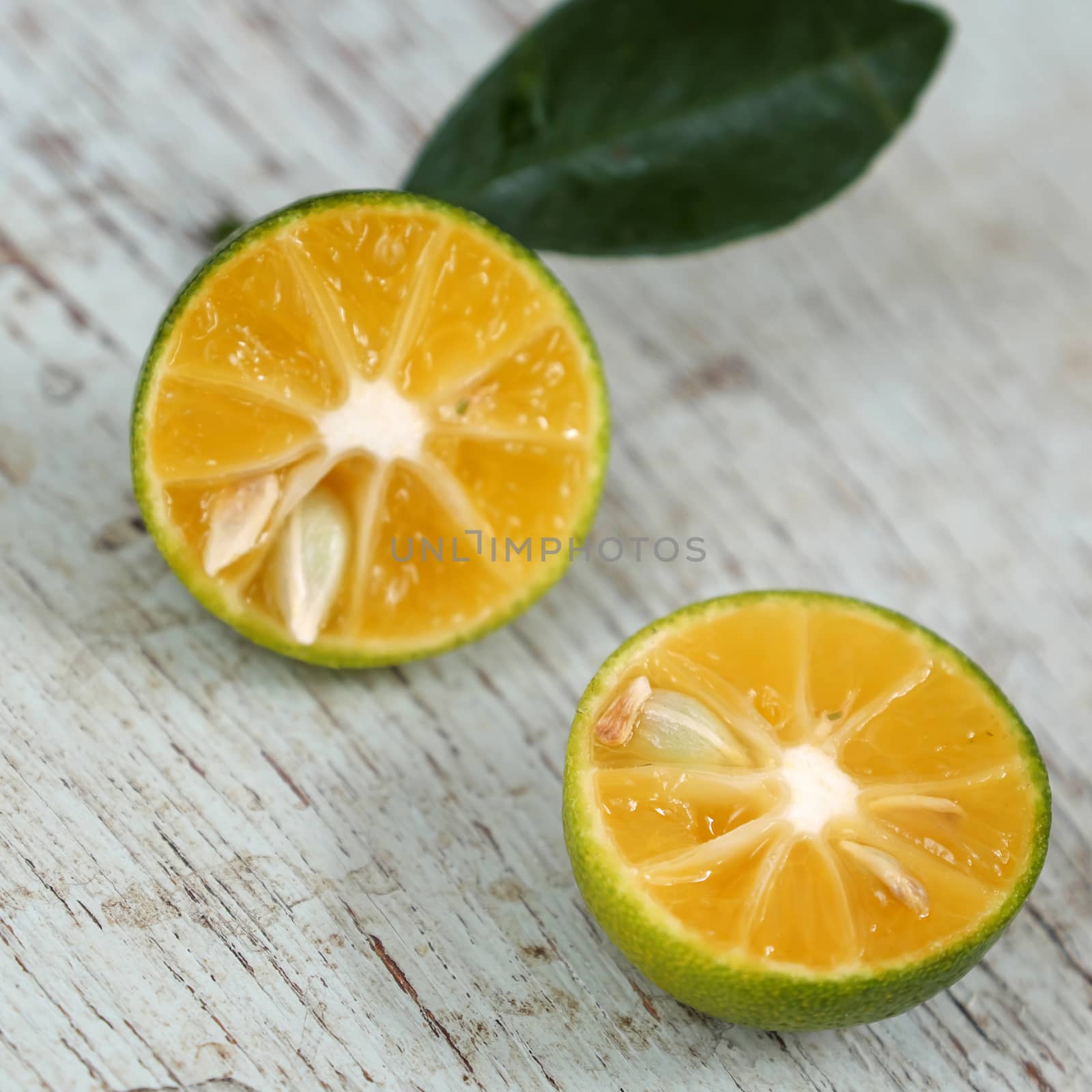 Green Kumquat fruit on wooden background by xuanhuongho