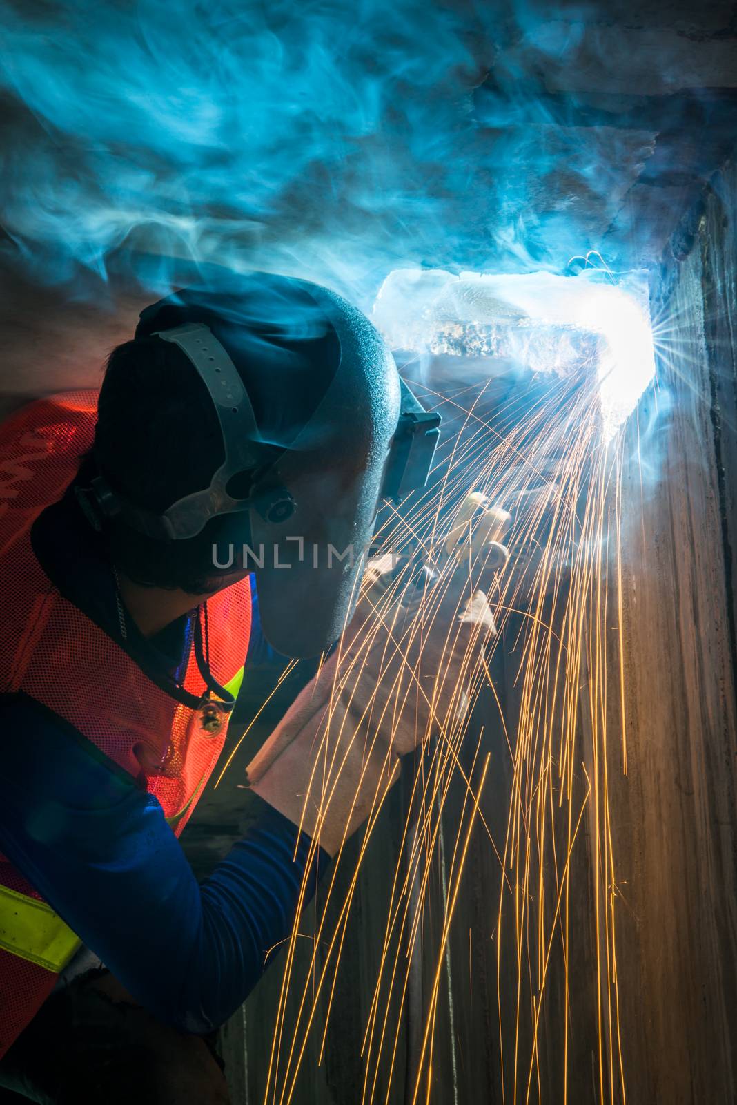 worker welding metal with sparks