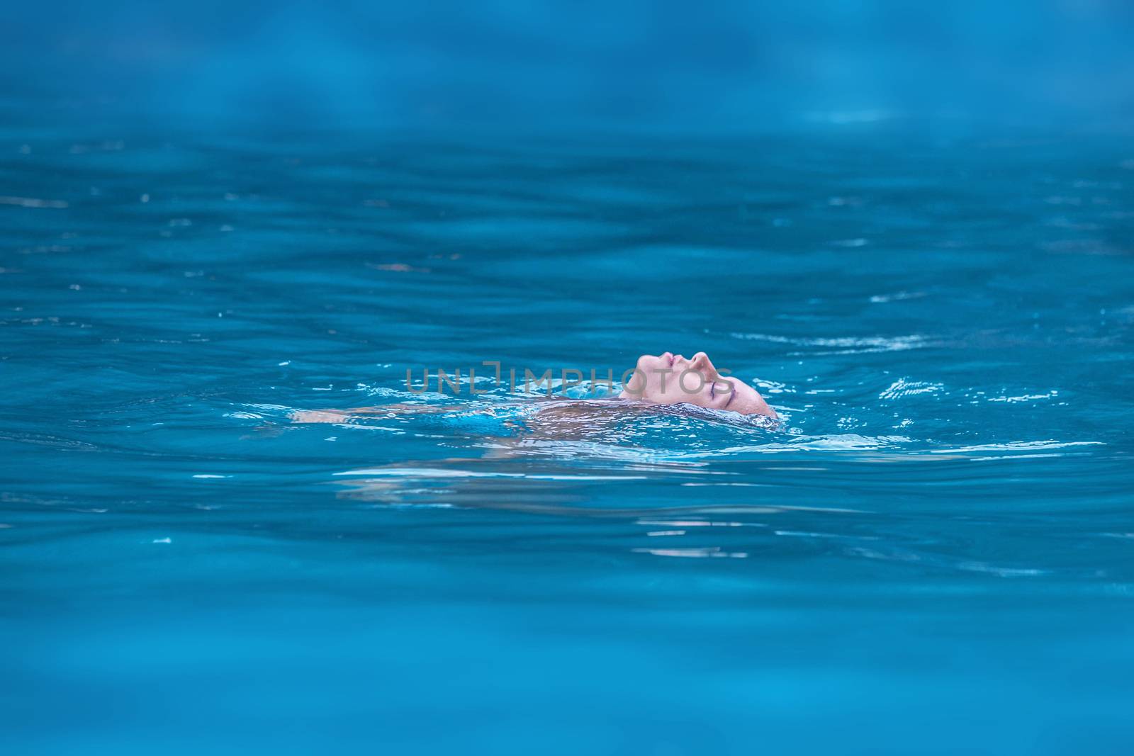 Woman floating and relaxing in tropical ocean water