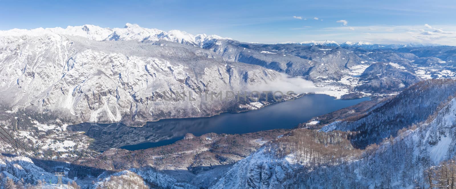A view of the Lake Bohinj and the surrounding mountains in winter.