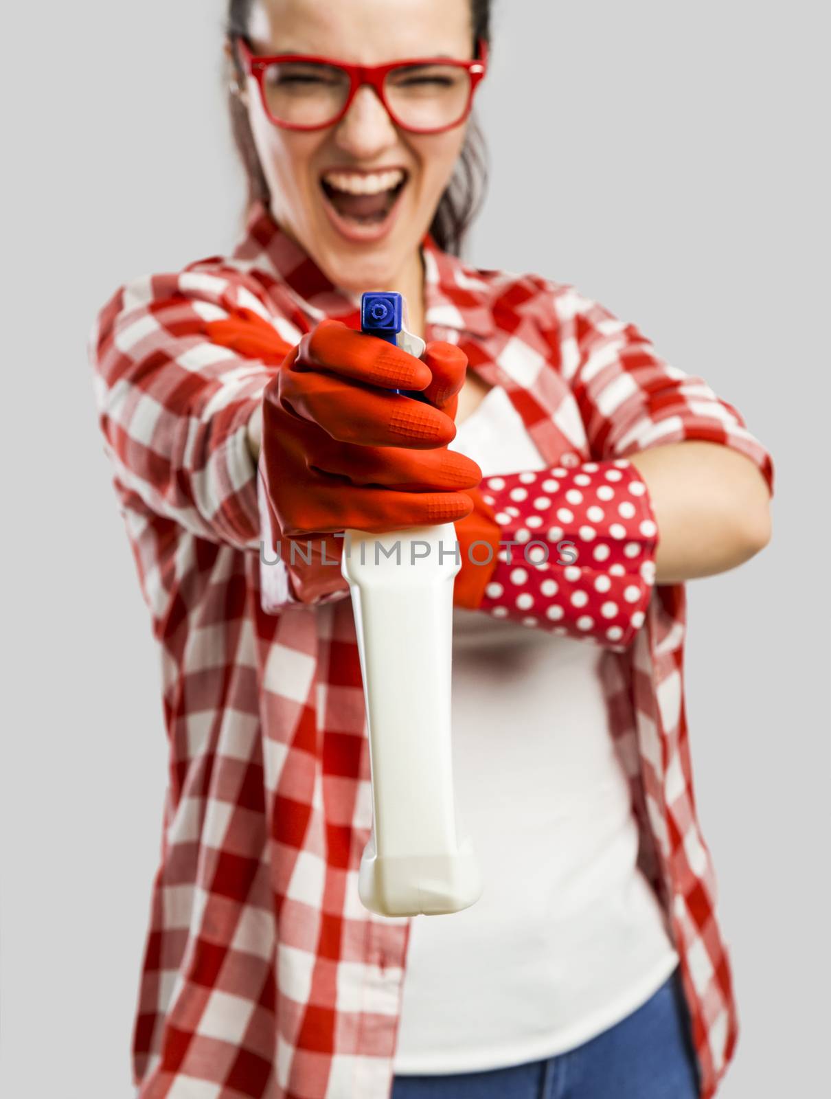 Pretty woman wearing gloves and holding a cleaning spray 