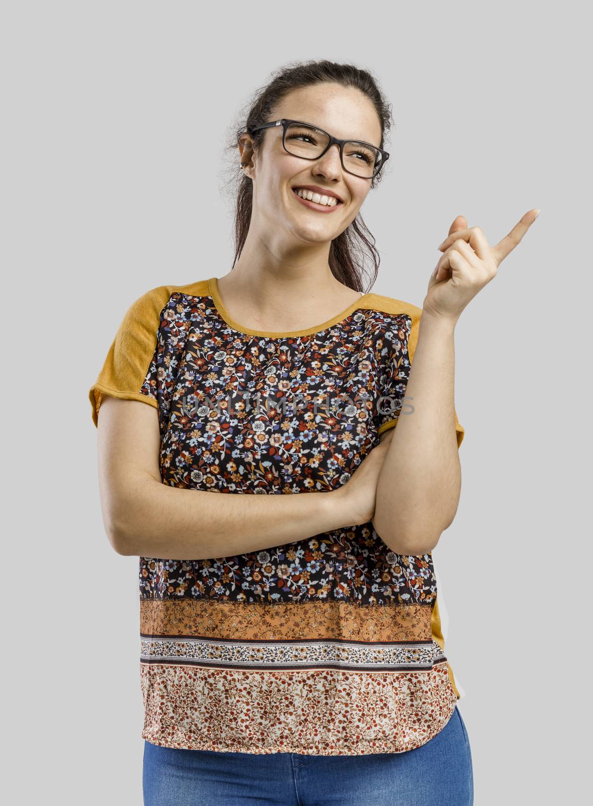 Beautiful and happy woman thinking, isolated over a gray background 