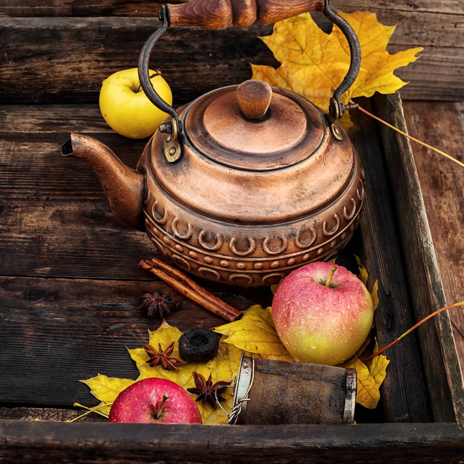 Stylish teapot,apples and maple leaf in rustic style