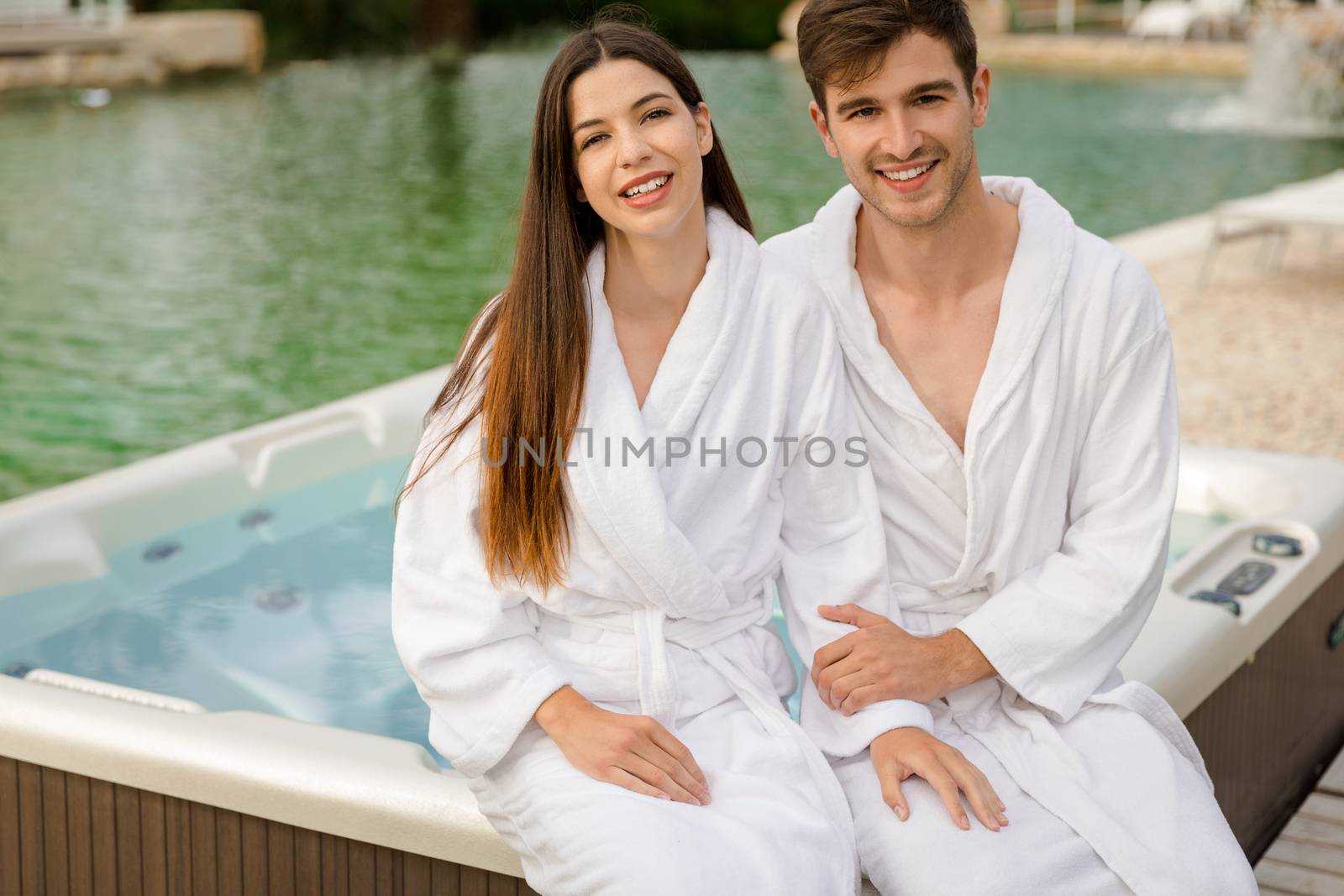 Young couple sitting near a jacuzzi in a luxury hotel