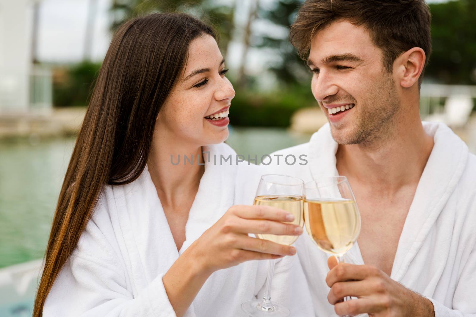 Young couple  in a luxury hotel tasting a glass of white wine