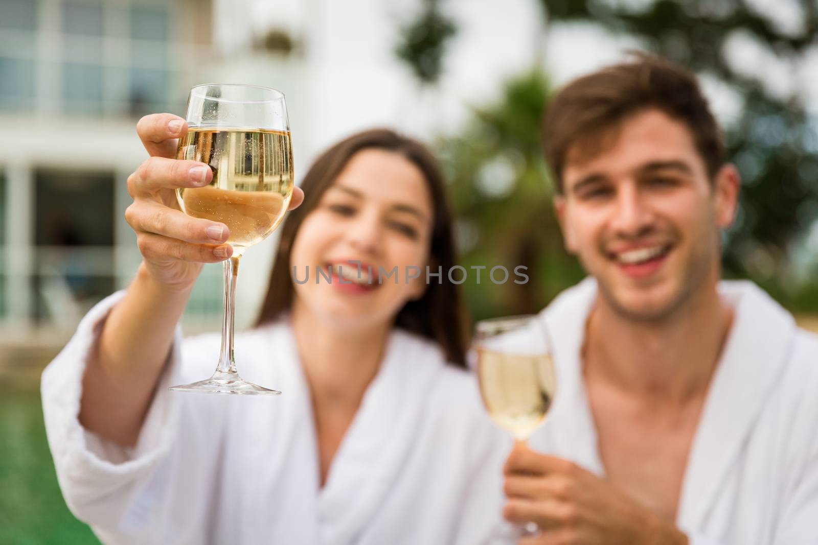 Young couple  in a luxury hotel tasting a glass of white wine