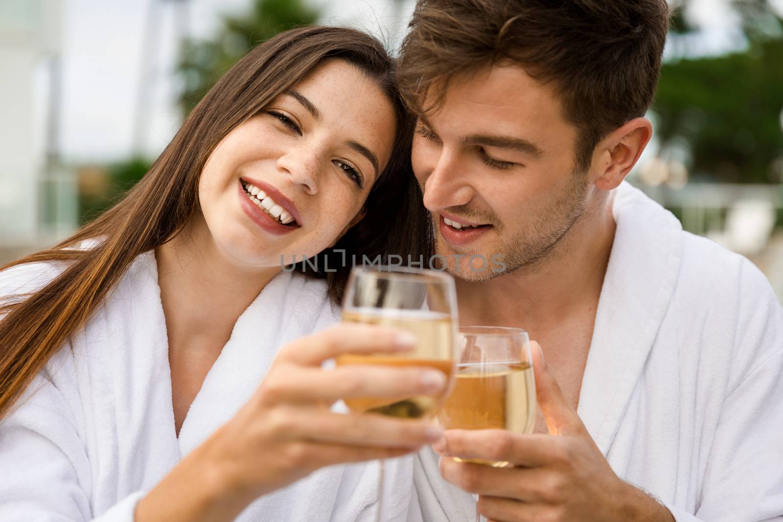 Young couple  in a luxury hotel tasting a glass of white wine