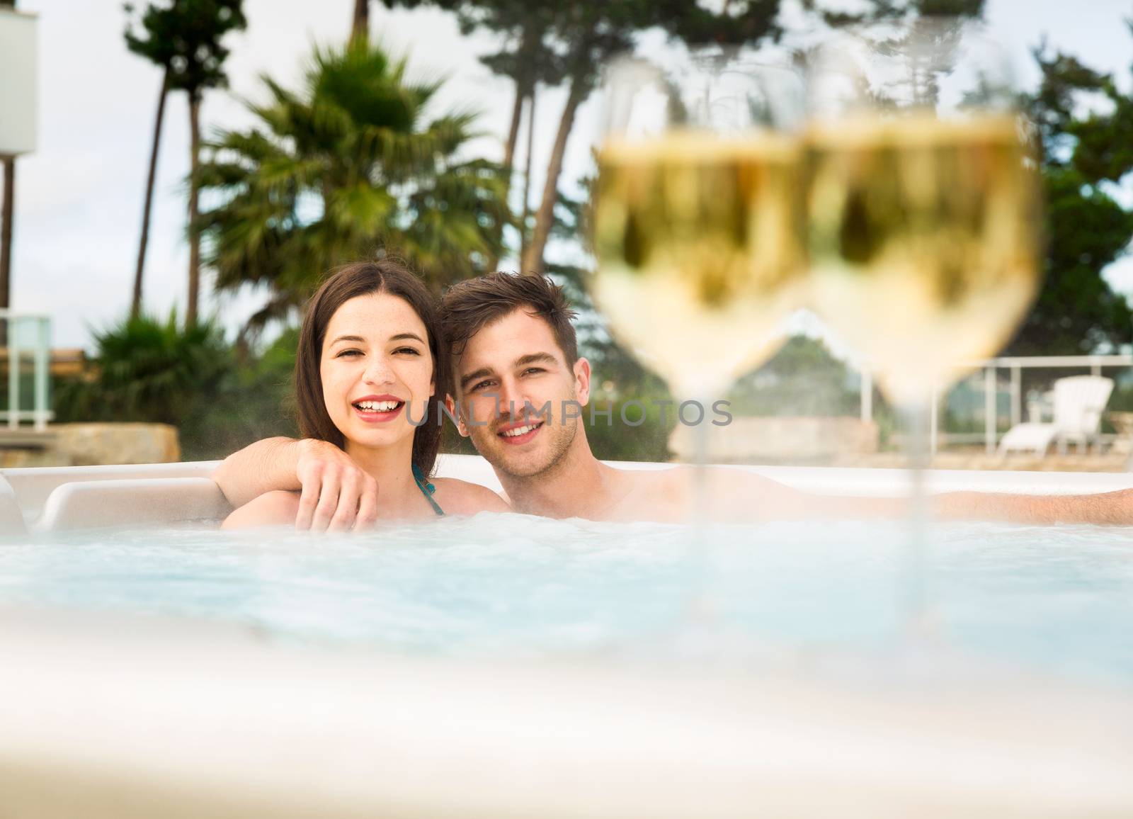 Young couple inside a jacuzzi and tasting wine