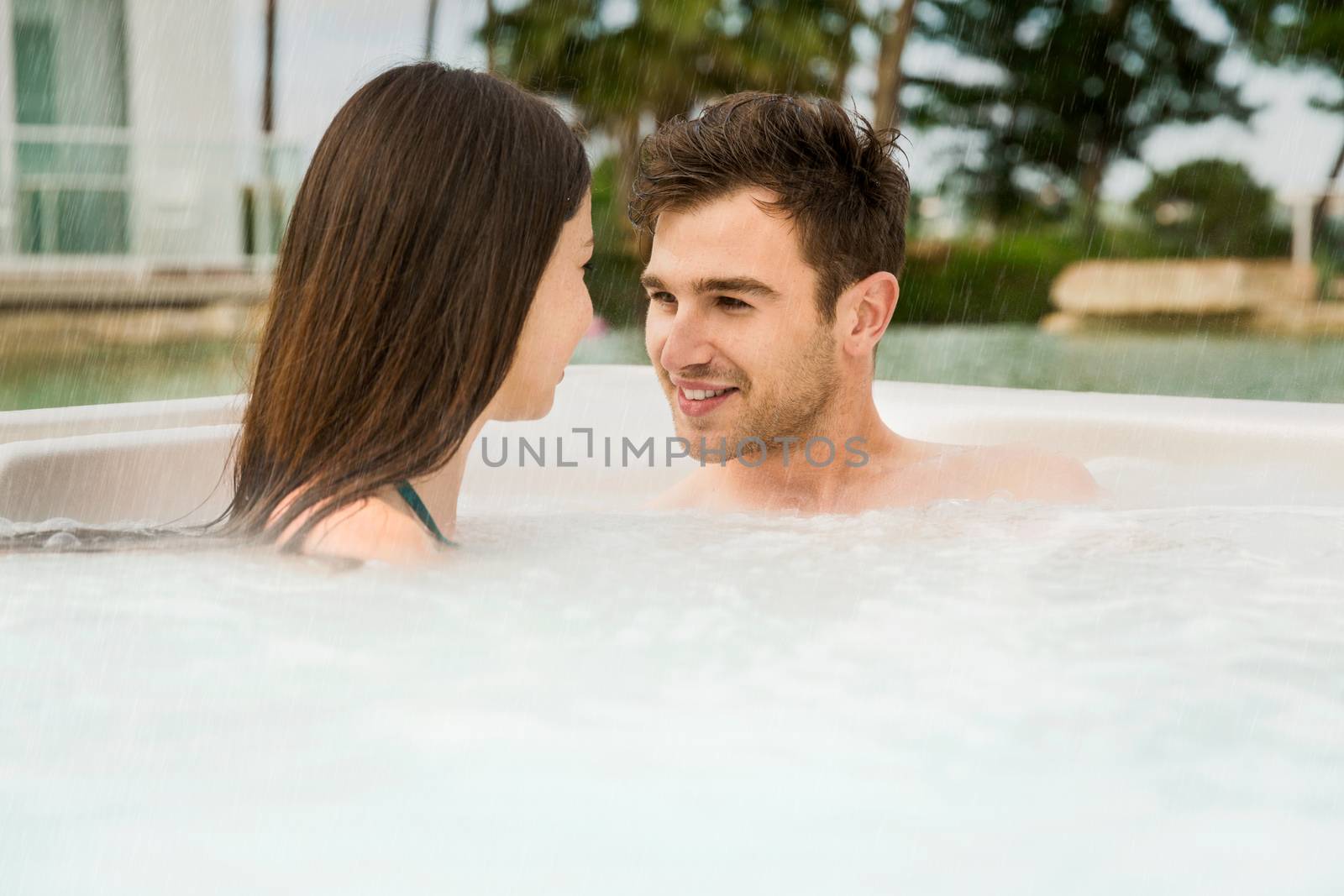 Young couple in a luxury hotel inside a jacuzzi enjoying the holidays