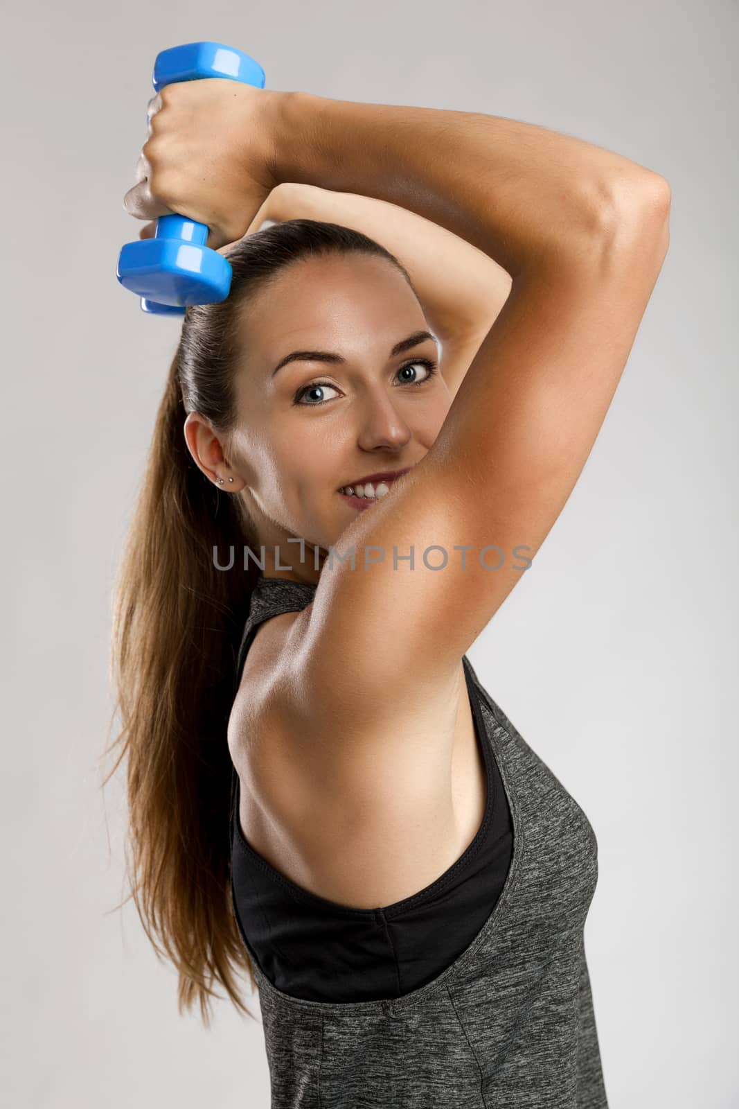 Young fitness woman making exercises with dumbbells