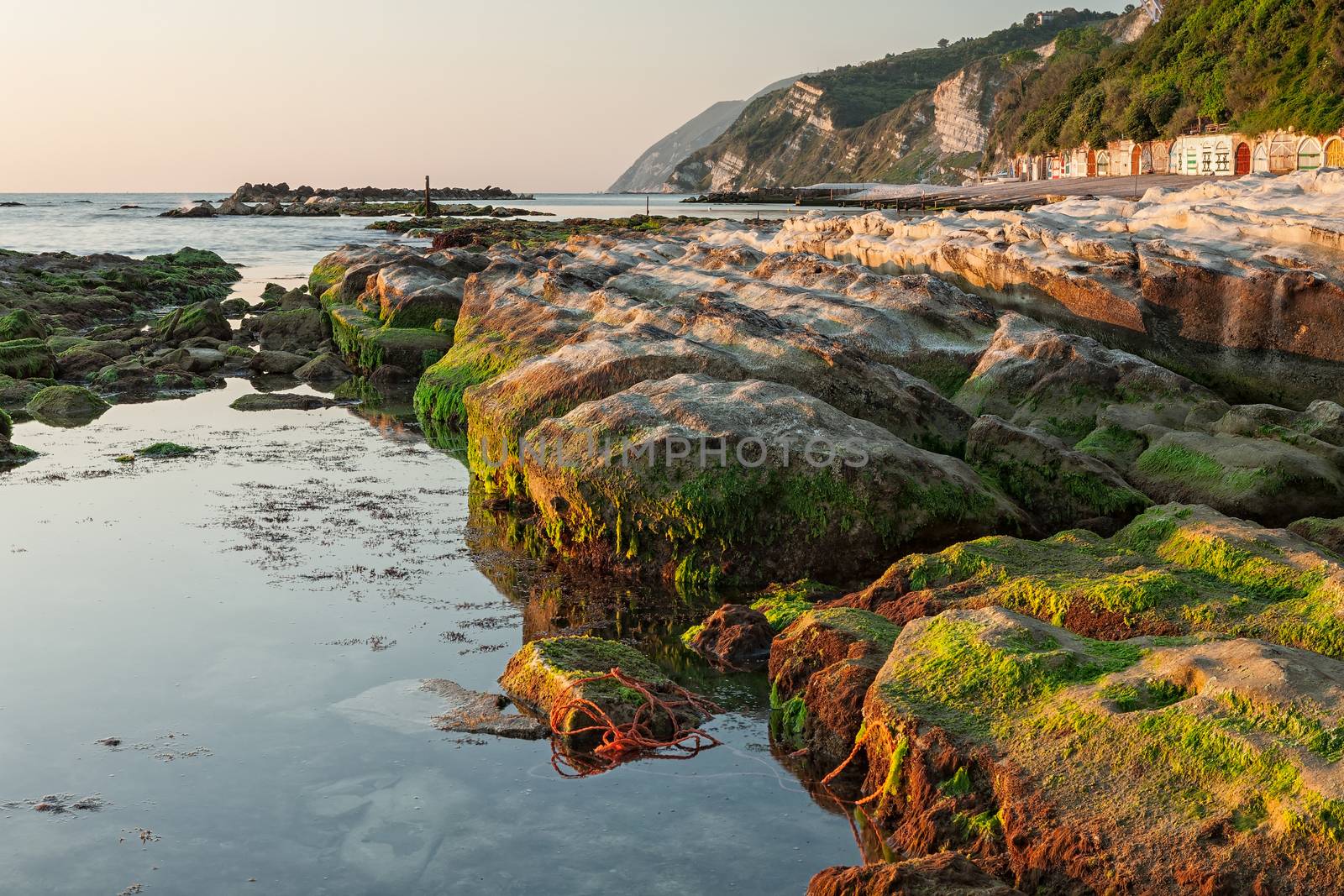 The passetto rocks reflected on the water at sunrise, Ancona, Italy