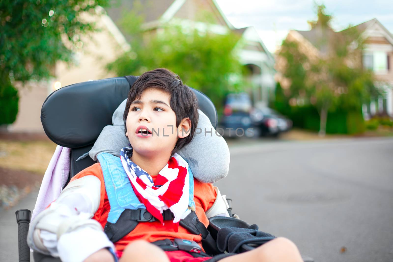 Young disabled boy in wheelchair looking up into sky by jarenwicklund