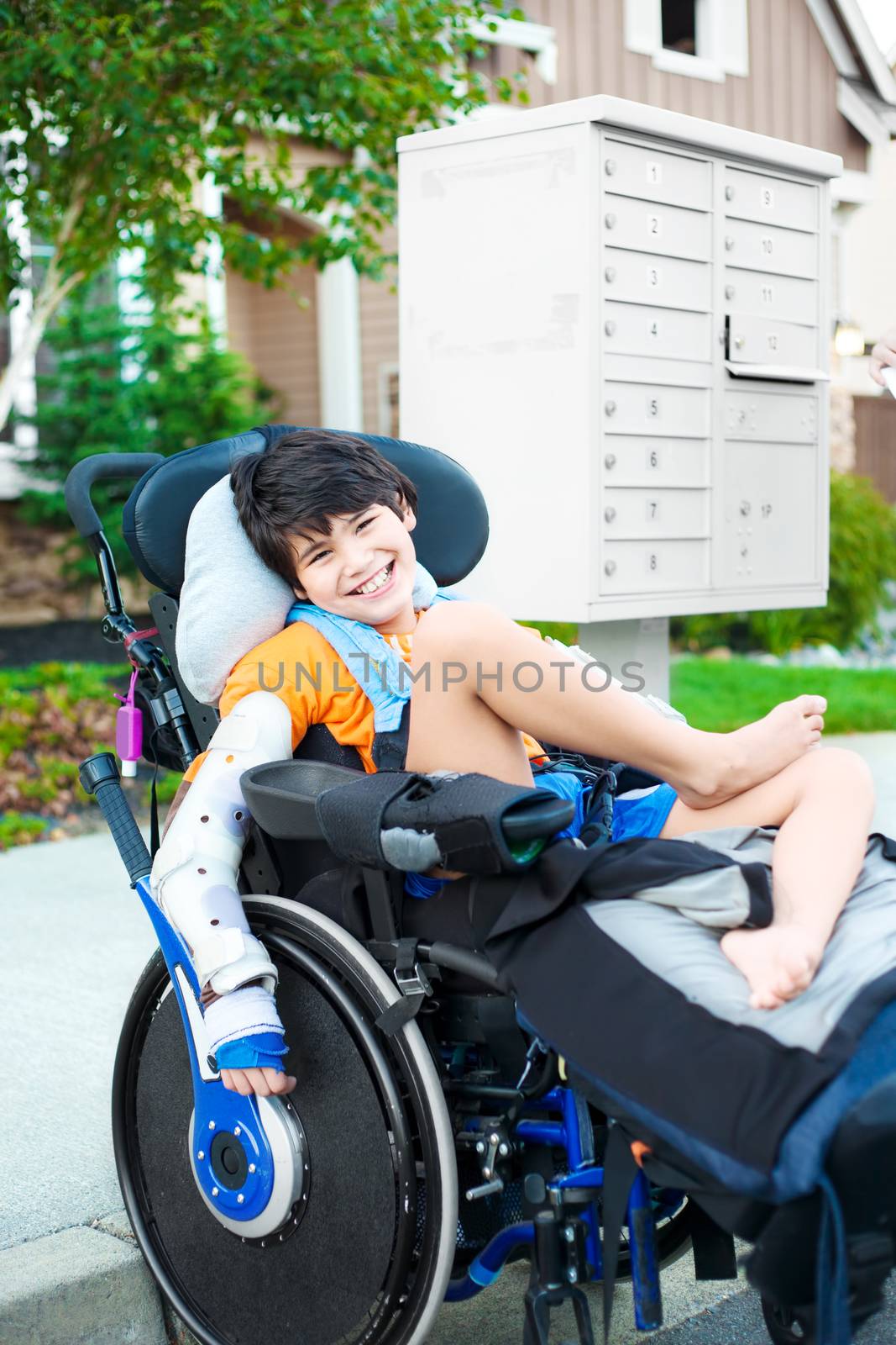 Handsome biracial disabled boy in wheelchair, smiling outdoor, r by jarenwicklund