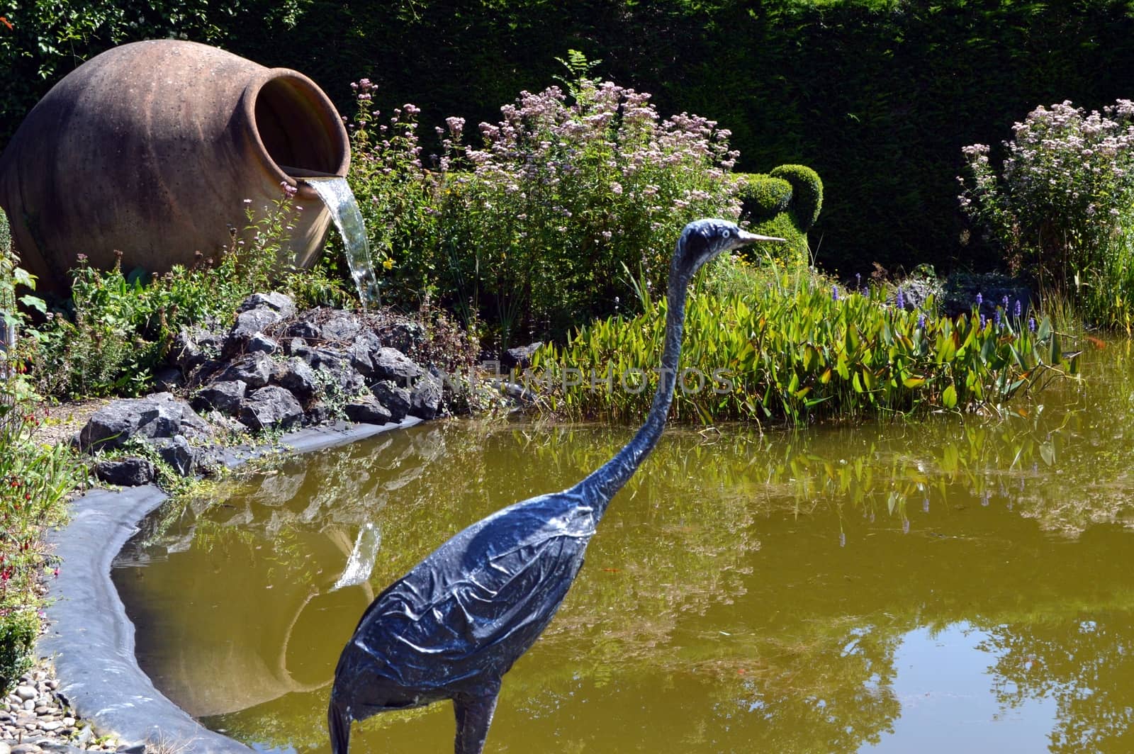 Puddle with a paper heron to chew, an amphora and reeds.