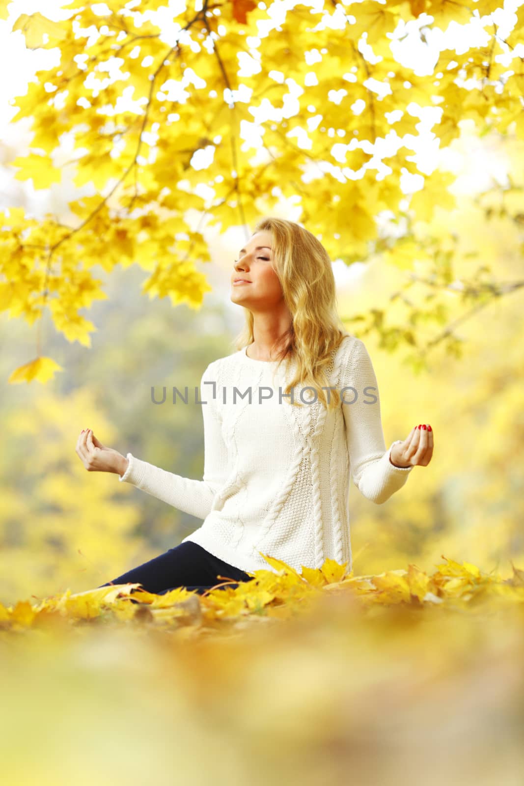 Woman meditating in autumn park by Yellowj