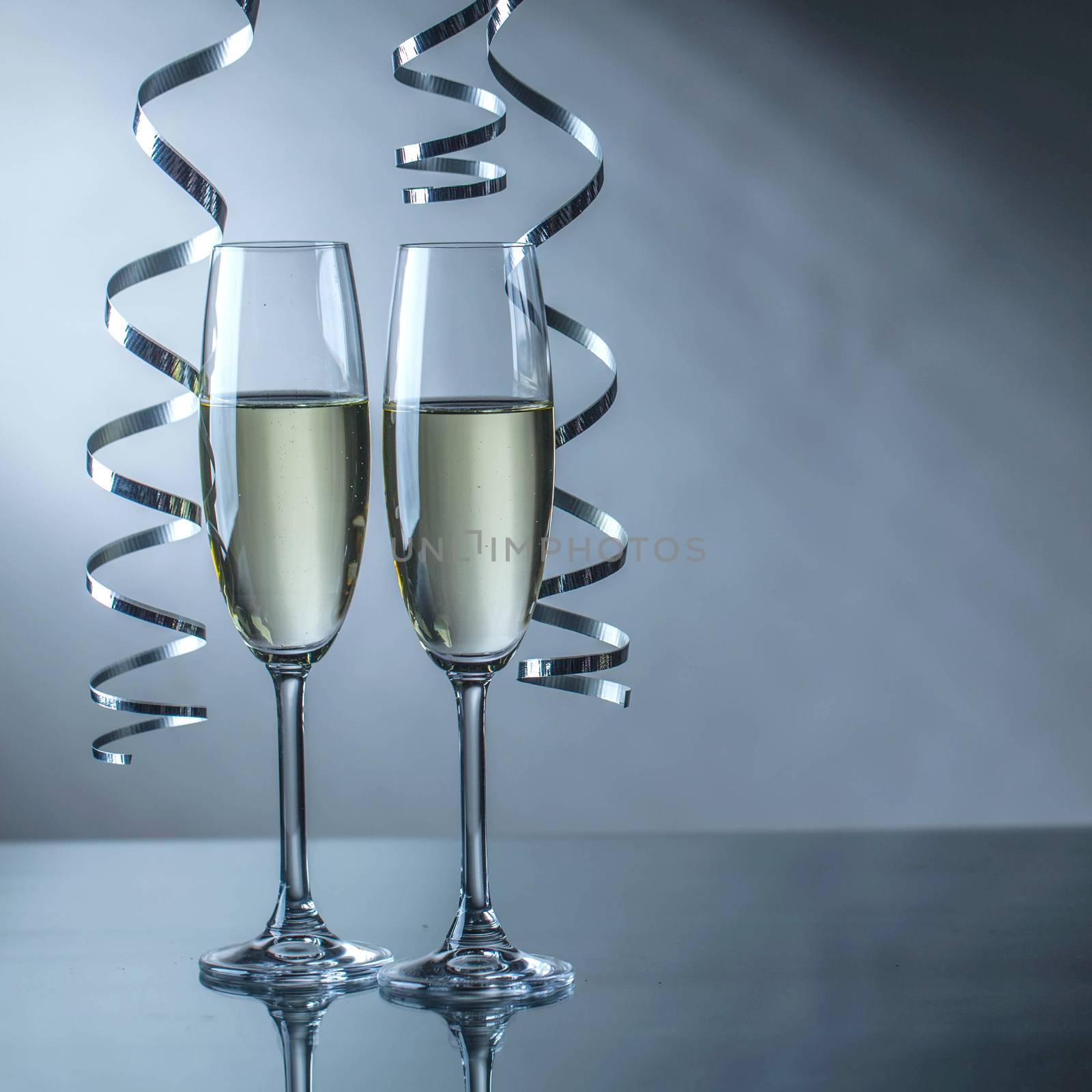 Two champagne glasses and curly ribbon party concept