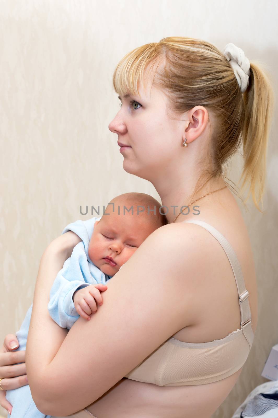 Newborn sleeping in mother's arms close up shot