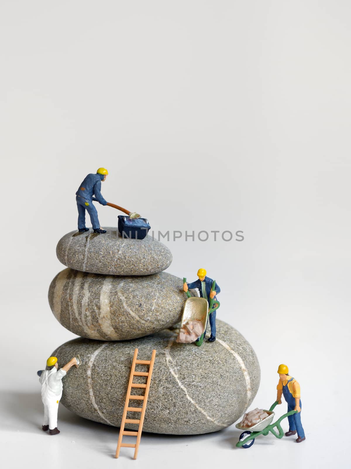 Pebbles stack and figurines of construction workers