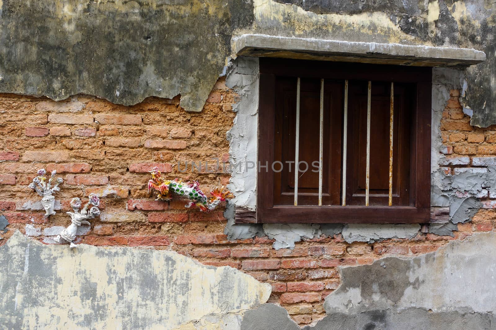 Georgetown, Penang, Malaysia - April 18, 2016: a old brick wall with wooden window by evolutionnow