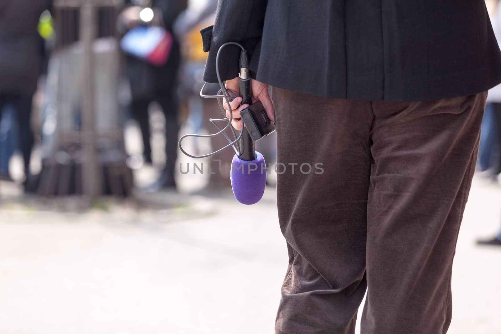 Reporter holding a microphone by wellphoto