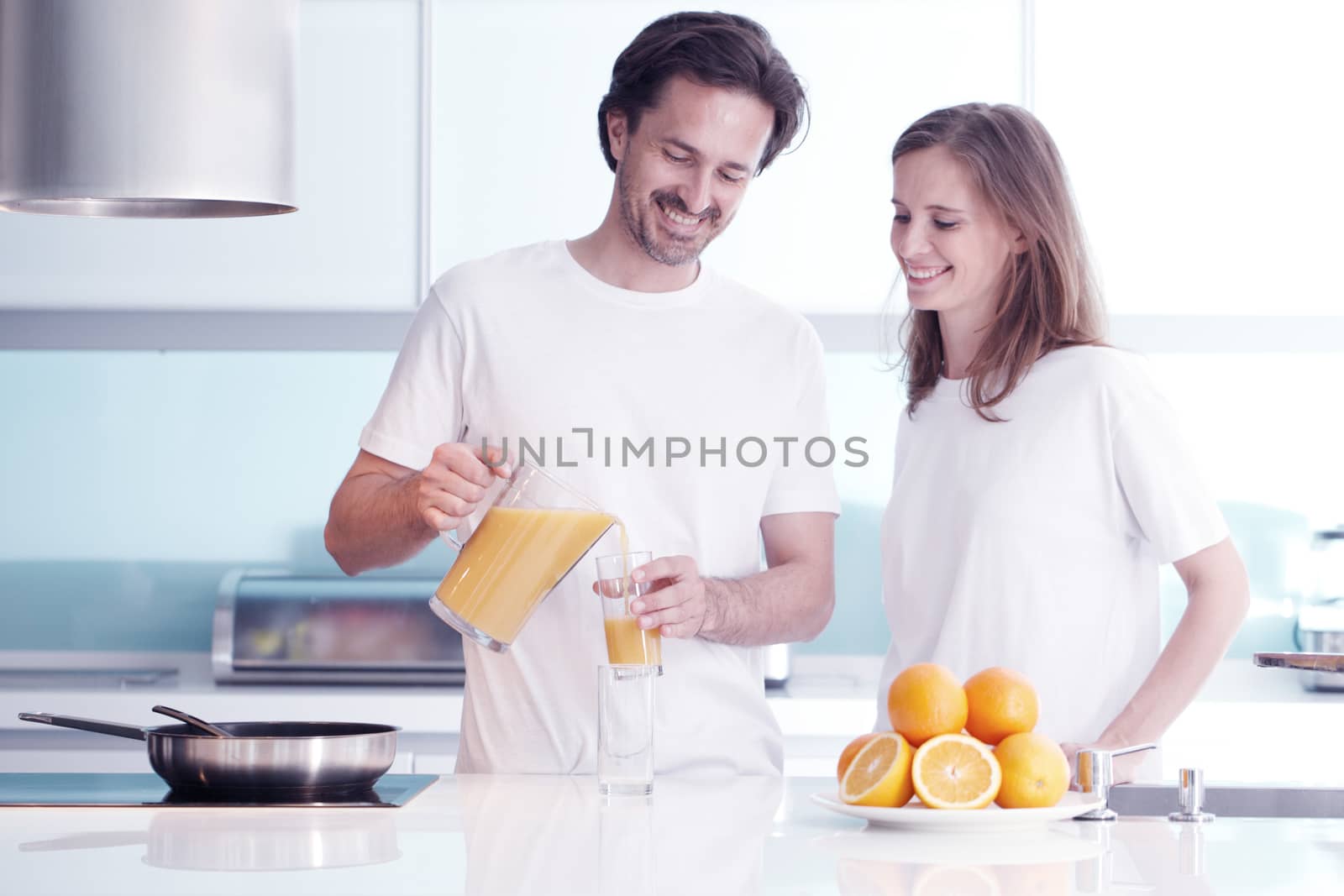 Couple with orange juice in the kitchen