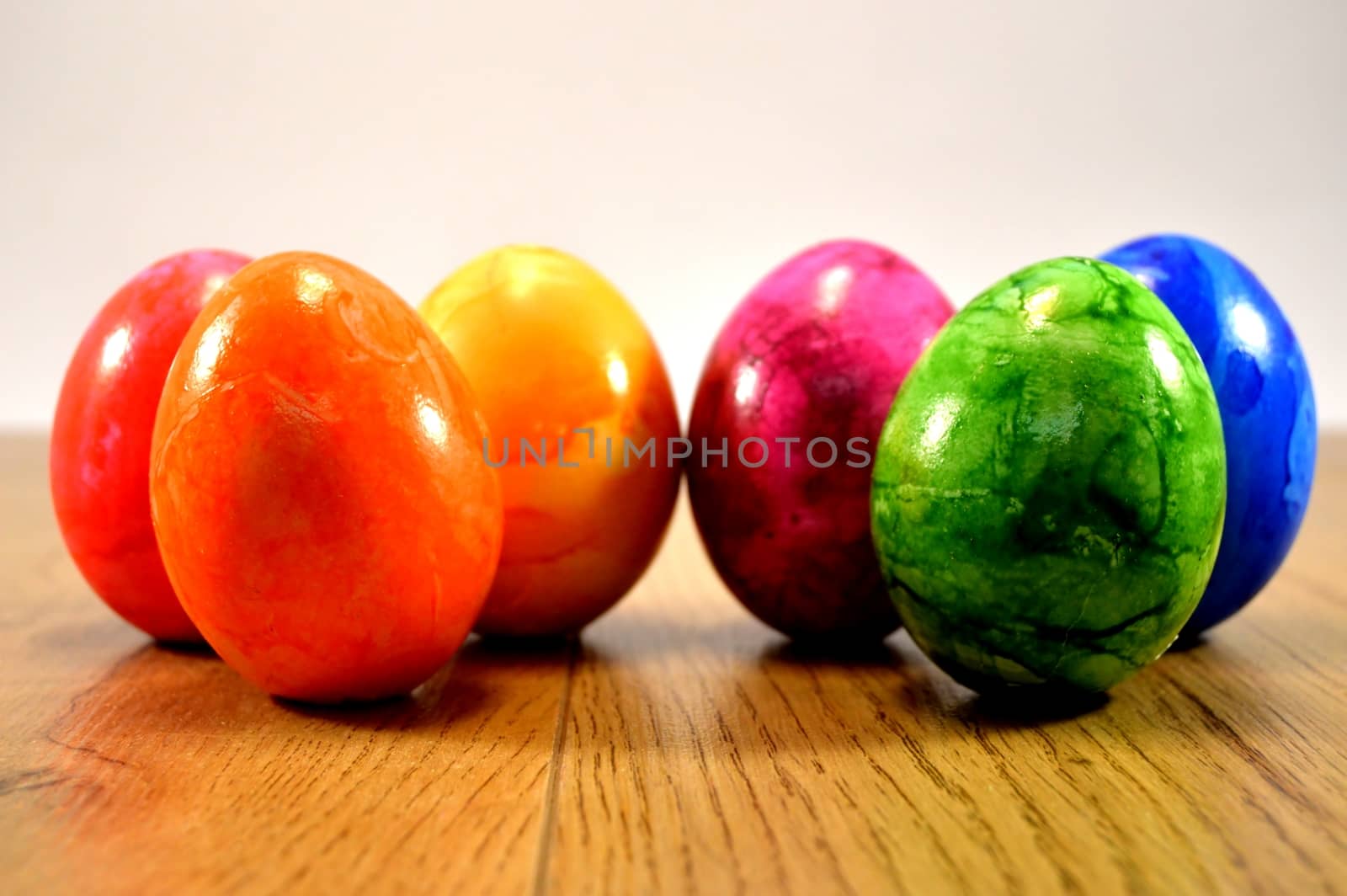 Six eggs of Easter rest up on a wooden ground