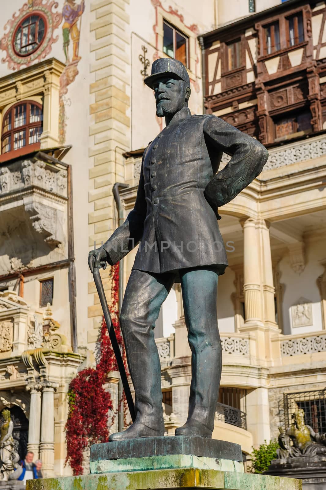 King Carol I Statue in front of beautiful Peles castle and ornamental garden in Sinaia, Romania, between Valachia and Transylvania