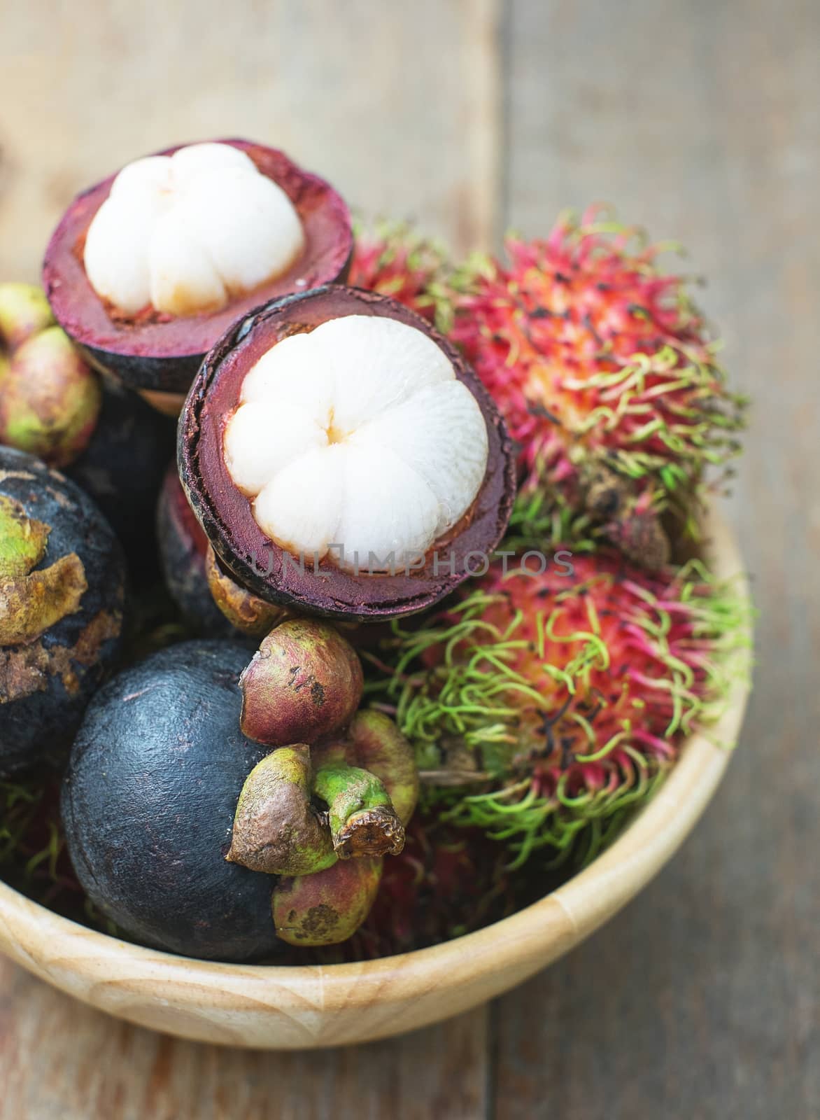 mangosteen and rambutan on wood table