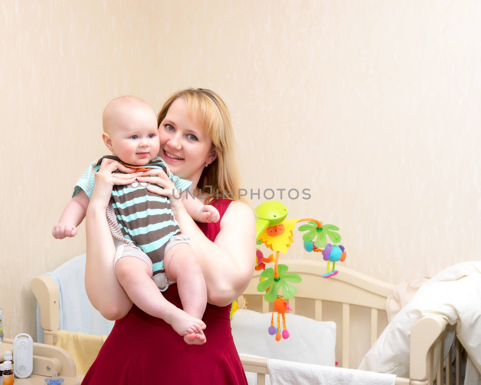 Indoor shot of happy mother holding smiling baby 