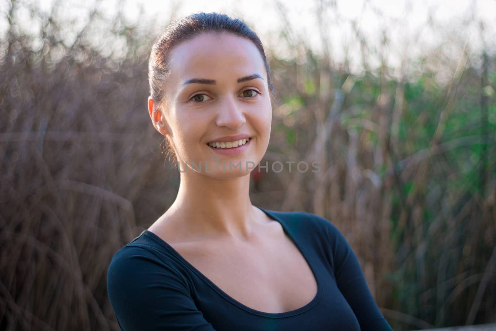 Young pretty woman portrait with water reed background