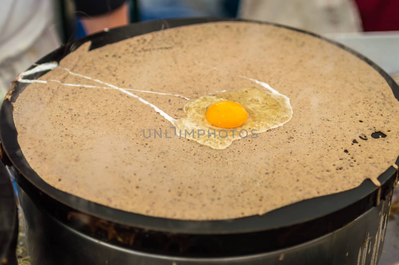 Raw egg on pancakes during preparation by okskukuruza