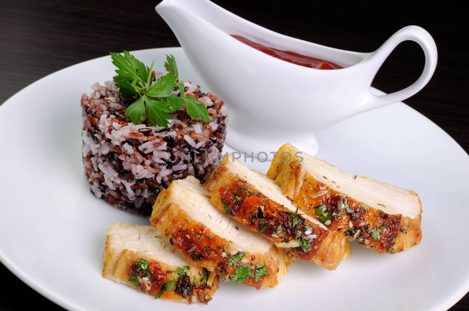 Slices of roasted chicken breast with  a variety rice and   tomato sauce