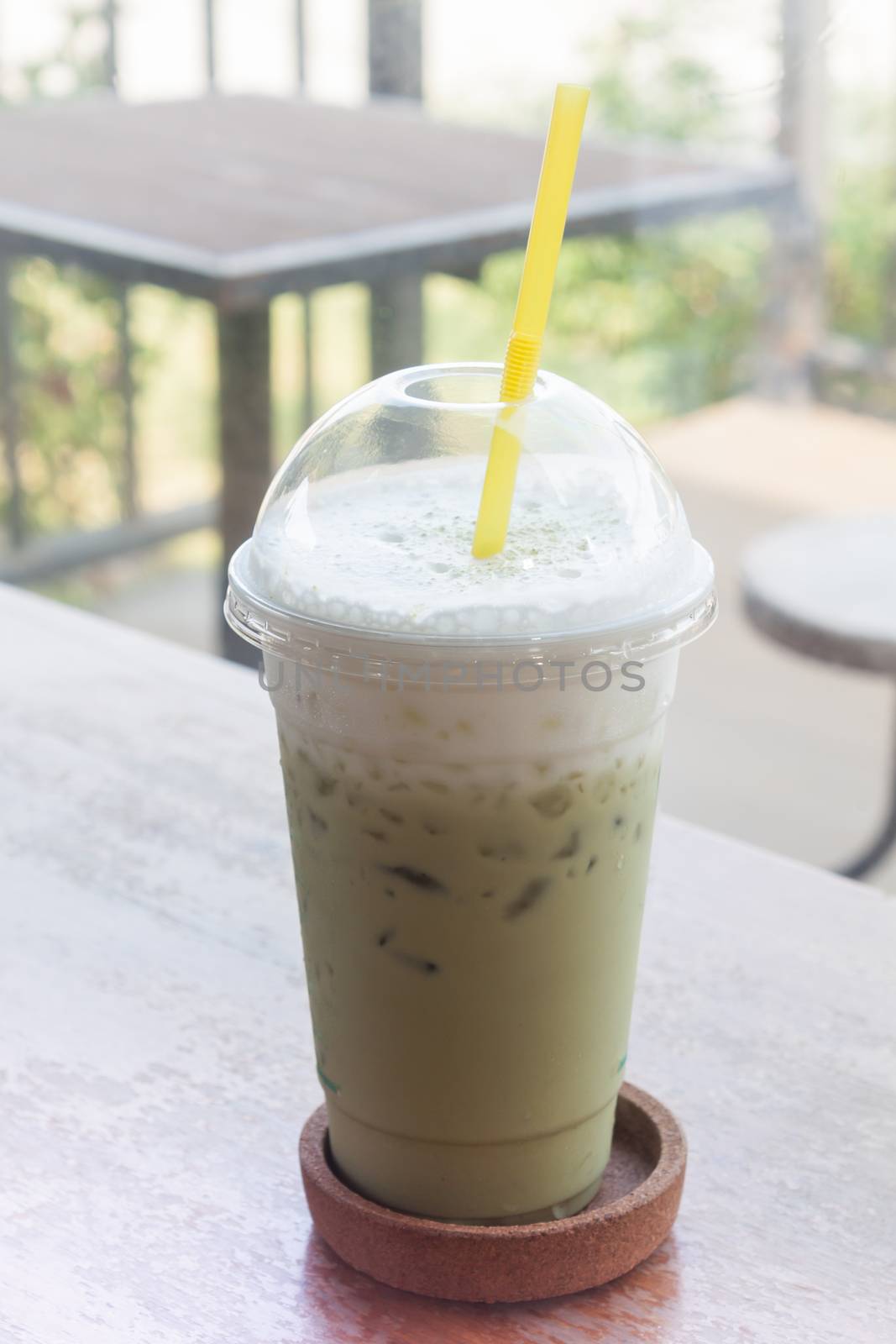 Iced green tea on wooden table by punsayaporn