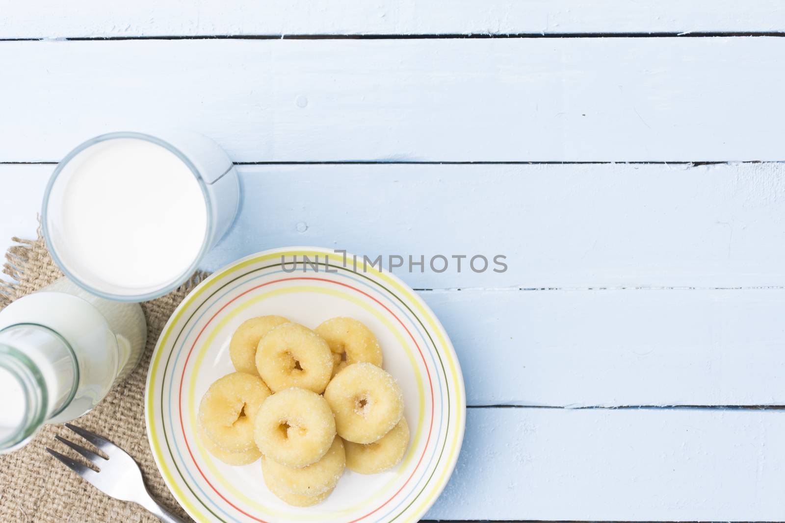 Donut dessert and milk bottle and milk glass  on wooden sky blue table.Meal or breakfast hi-vitamin and calcium.141