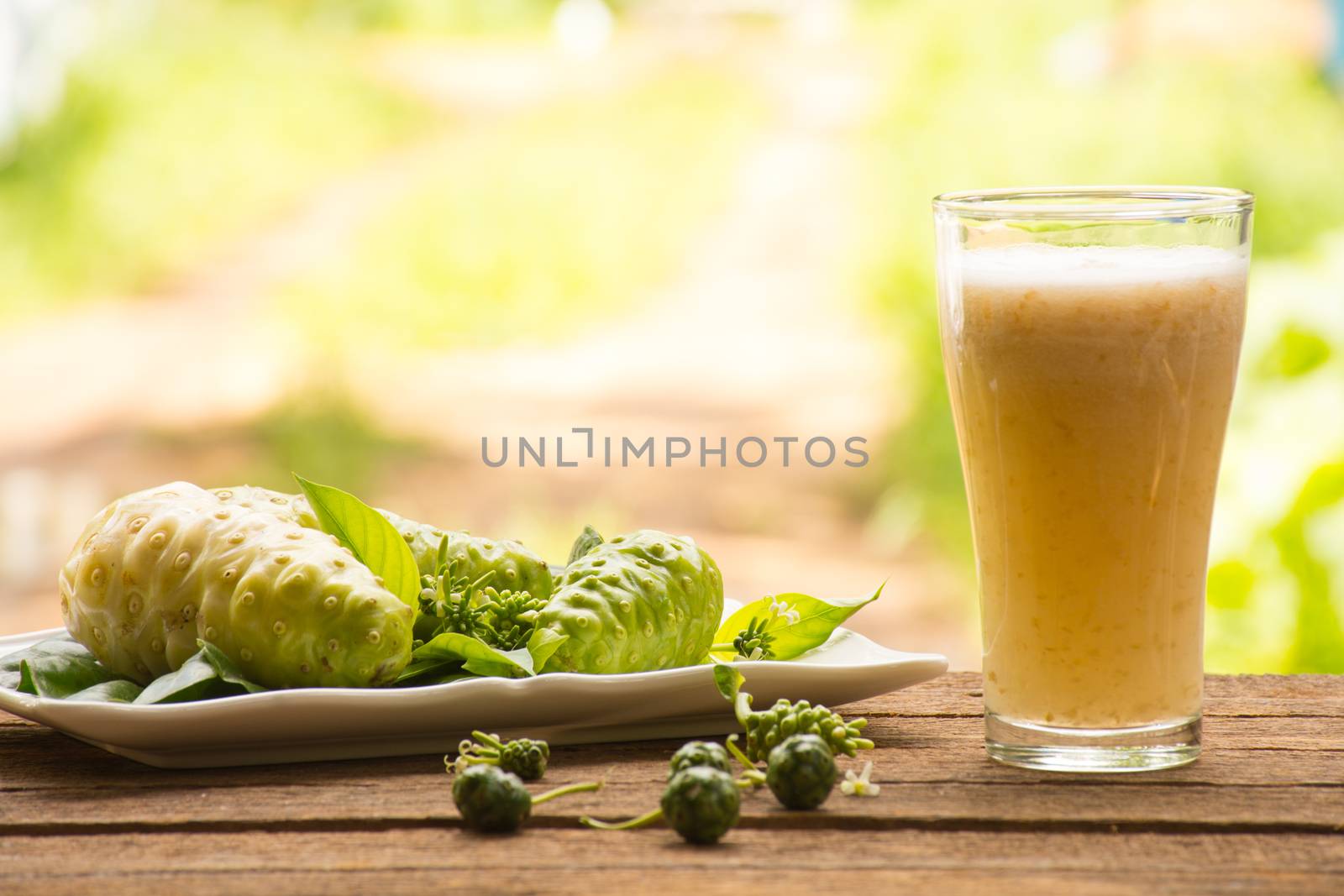 Noni and noni juice on wooden background.Juice for health or fruit for health or herb for health.Outdoor view11