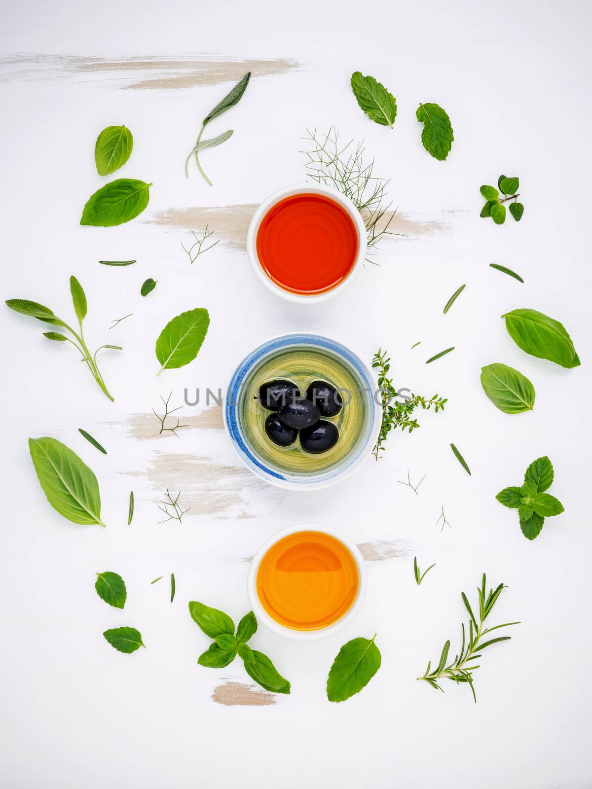 Different sorts of cooking oils. Olive oil flavored ,spice oils and sesame oil with herbs rosemary ,thyme,dill,sage ,peppermint ,oregano , sweet basil and parsley setup with shabby wooden background .