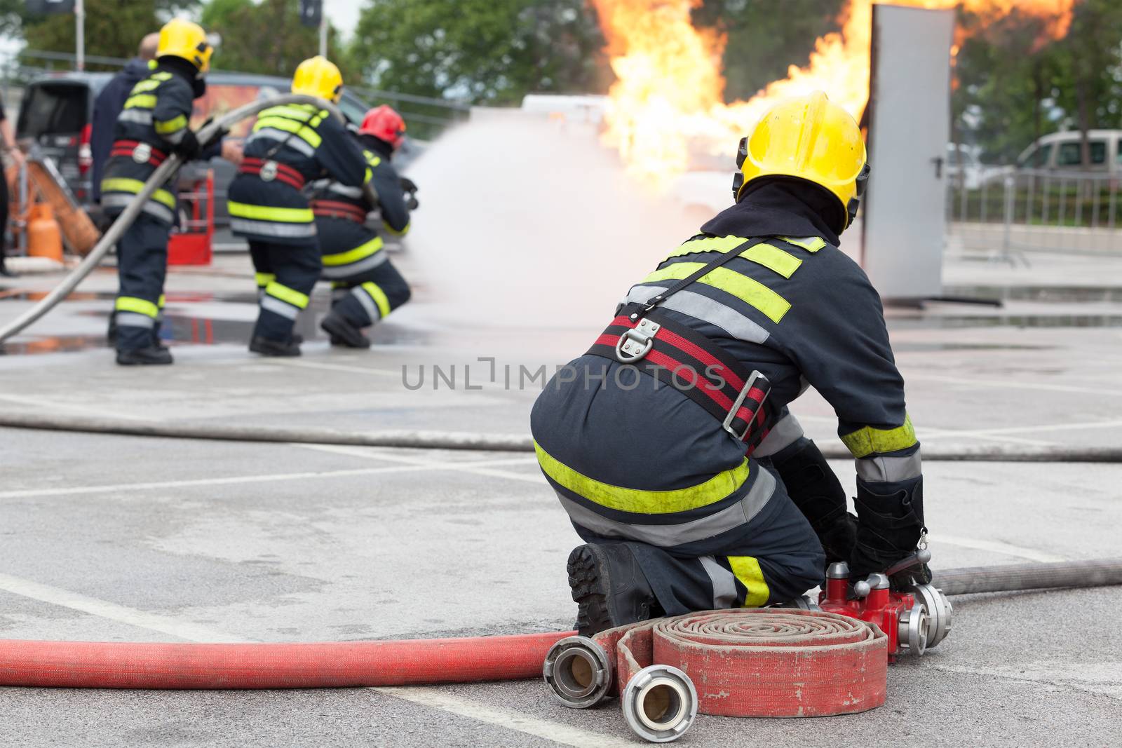 Firefighters spraying water in fire fighting training operation