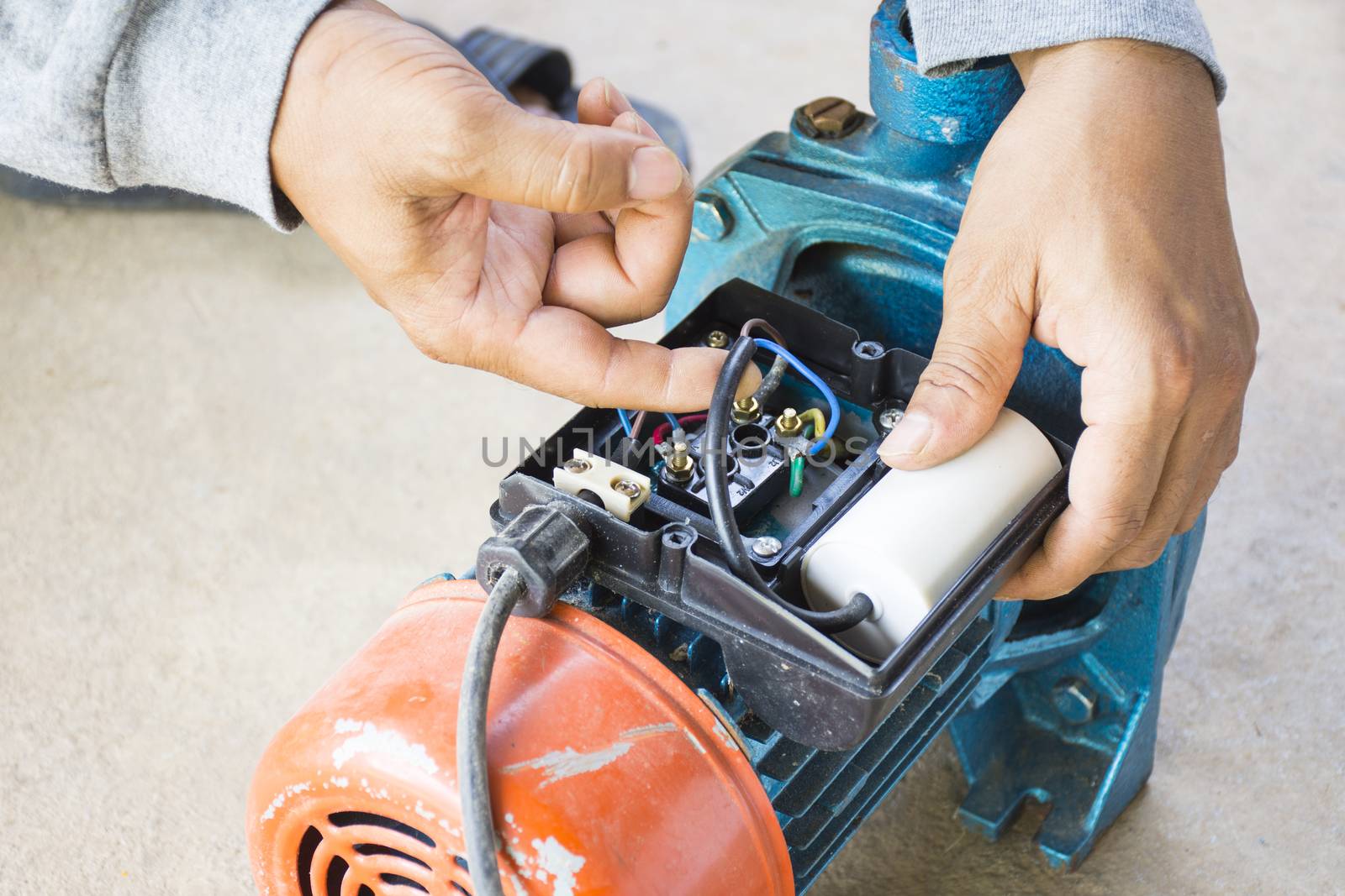 Electric motor  and man working equipment repair on cement floor background.Background motor or equipment.Zoom in 001