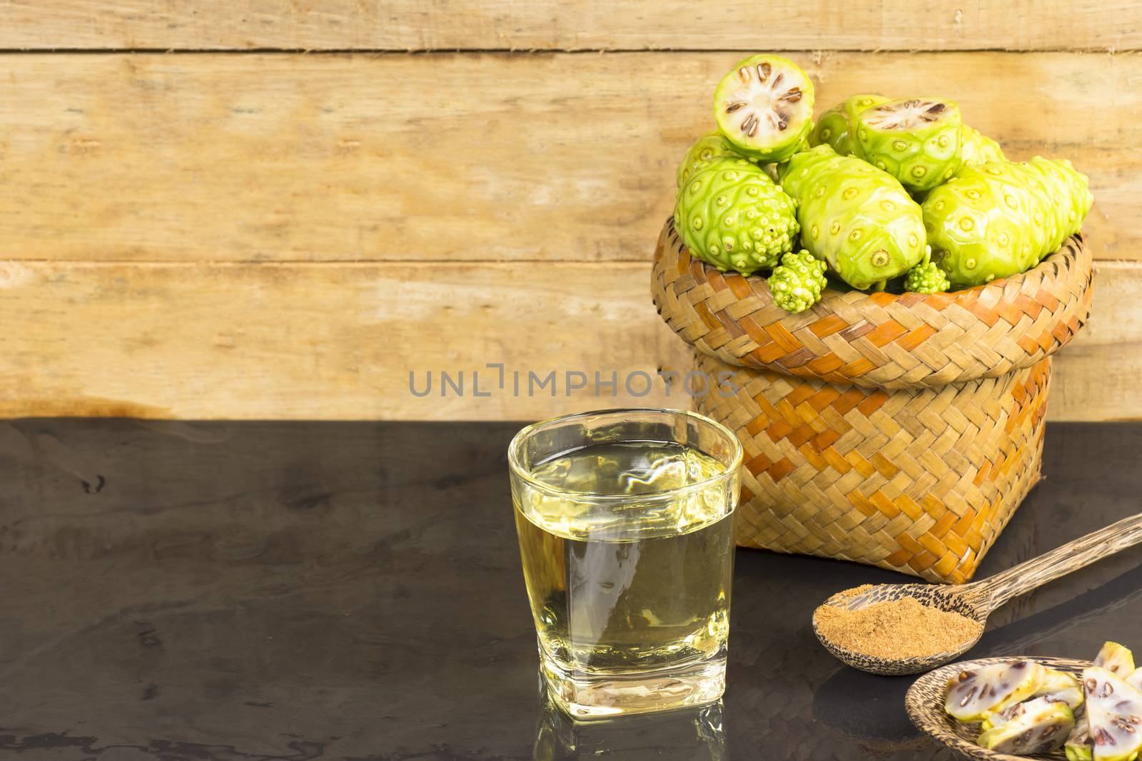 Noni fruit  and noni juice with noni powder on black table.Fruit for health and herb for health.11121